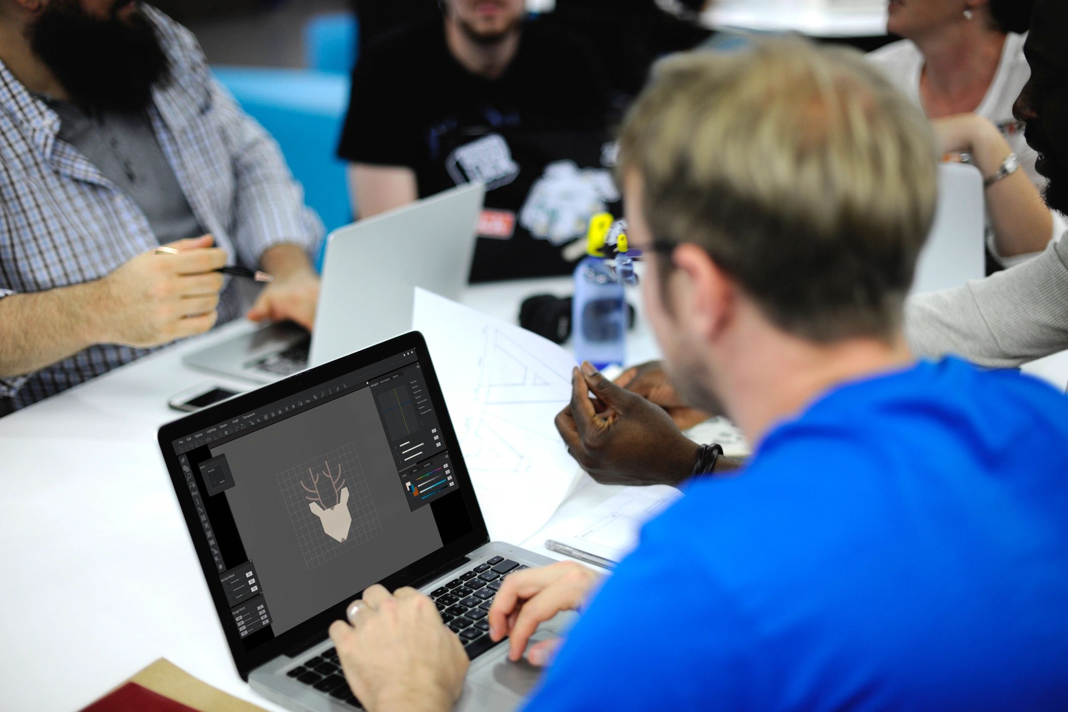 People collaborating around a laptop during a data review